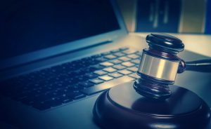 Legal law concept image gavel on computer laptop with book in background